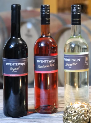 Three wine bottles: white, rosé, and black, labeled 'Twente Wijn' from Wijngaard.