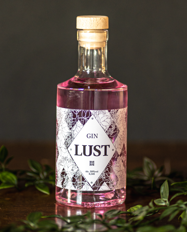 Botella transparente con licor rosa etiquetado 'Gin Lust.'